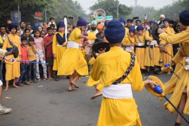 Delhi, Hindistan, 17 Kasım 2024 - Doğu Delhi bölgesinde Guru Nanak Dev, Nagar Kirtan 'ın doğum günü dolayısıyla geleneksel Nagar Kirtan, geleneksel Nagar geçit töreninde Sihler gatka ve dövüş sanatlarını sergiliyor