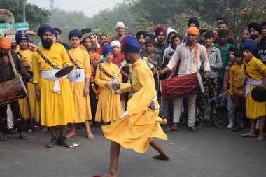Delhi, Hindistan, 17 Kasım 2024 - Doğu Delhi bölgesinde Guru Nanak Dev, Nagar Kirtan 'ın doğum günü dolayısıyla geleneksel Nagar Kirtan, geleneksel Nagar geçit töreninde Sihler gatka ve dövüş sanatlarını sergiliyor