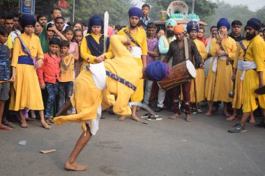 Delhi, Hindistan, 17 Kasım 2024 - Doğu Delhi bölgesinde Guru Nanak Dev, Nagar Kirtan 'ın doğum günü dolayısıyla geleneksel Nagar Kirtan, geleneksel Nagar geçit töreninde Sihler gatka ve dövüş sanatlarını sergiliyor