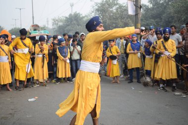 Delhi, Hindistan, 17 Kasım 2024 - Doğu Delhi bölgesinde Guru Nanak Dev, Nagar Kirtan 'ın doğum günü dolayısıyla geleneksel Nagar Kirtan, geleneksel Nagar geçit töreninde Sihler gatka ve dövüş sanatlarını sergiliyor