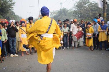 Delhi, Hindistan, 17 Kasım 2024 - Doğu Delhi bölgesinde Guru Nanak Dev, Nagar Kirtan 'ın doğum günü dolayısıyla geleneksel Nagar Kirtan, geleneksel Nagar geçit töreninde Sihler gatka ve dövüş sanatlarını sergiliyor