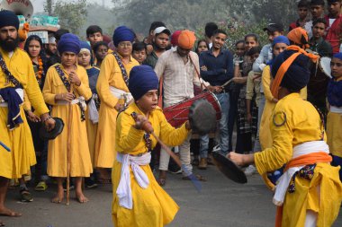 Delhi, Hindistan, 17 Kasım 2024 - Doğu Delhi bölgesinde Guru Nanak Dev, Nagar Kirtan 'ın doğum günü dolayısıyla geleneksel Nagar Kirtan, geleneksel Nagar geçit töreninde Sihler gatka ve dövüş sanatlarını sergiliyor