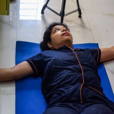 Evde yoga yapan genç Hintli bir kadın çevrimiçi yoga seansında güzel bir kız temel yoga pozisyonunda Asyalı bir kadın kapalı alanda yoga yapıyor.