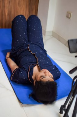 Evde yoga yapan genç Hintli bir kadın çevrimiçi yoga seansında güzel bir kız temel yoga pozisyonunda Asyalı bir kadın kapalı alanda yoga yapıyor.