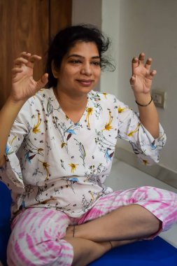 Evde yoga yapan genç Hintli bir kadın çevrimiçi yoga seansında güzel bir kız temel yoga pozisyonunda Asyalı bir kadın kapalı alanda yoga yapıyor.