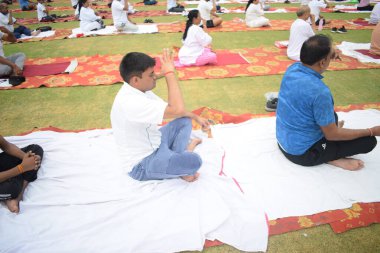 Yeni Delhi, Hindistan, 21 Haziran 2025 - Uluslararası Yoga Günü 'nde Delhi' deki Yamuna Spor Kompleksi 'nde grup Yoga egzersiz oturumu, kriket stadyumunda yoga sınıfına katılan büyük bir grup yetişkin