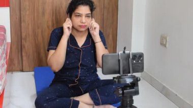 Evde yoga yapan genç Hintli bir kadın çevrimiçi yoga seansında güzel bir kız temel yoga pozisyonunda Asyalı bir kadın kapalı alanda yoga yapıyor. 