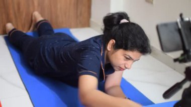 Evde yoga yapan genç Hintli bir kadın çevrimiçi yoga seansında güzel bir kız temel yoga pozisyonunda Asyalı bir kadın kapalı alanda yoga yapıyor. 