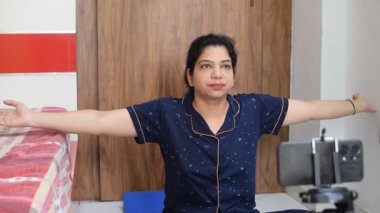 Evde yoga yapan genç Hintli bir kadın çevrimiçi yoga seansında güzel bir kız temel yoga pozisyonunda Asyalı bir kadın kapalı alanda yoga yapıyor. 