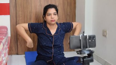 Evde yoga yapan genç Hintli bir kadın çevrimiçi yoga seansında güzel bir kız temel yoga pozisyonunda Asyalı bir kadın kapalı alanda yoga yapıyor. 