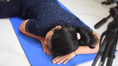 Evde yoga yapan genç Hintli bir kadın çevrimiçi yoga seansında güzel bir kız temel yoga pozisyonunda Asyalı bir kadın kapalı alanda yoga yapıyor. 