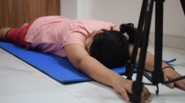 Evde yoga yapan genç Hintli bir kadın çevrimiçi yoga seansında güzel bir kız temel yoga pozisyonunda Asyalı bir kadın kapalı alanda yoga yapıyor. 