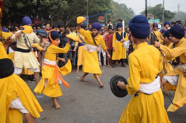 Delhi, Hindistan, 17 Kasım 2024 - Doğu Delhi bölgesinde Guru Nanak Dev, Nagar Kirtan 'ın doğum günü dolayısıyla geleneksel Nagar Kirtan, geleneksel Nagar geçit töreninde Sihler gatka ve dövüş sanatlarını sergiliyor