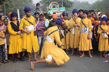 Delhi, Hindistan, 17 Kasım 2024 - Doğu Delhi bölgesinde Guru Nanak Dev, Nagar Kirtan 'ın doğum günü dolayısıyla geleneksel Nagar Kirtan, geleneksel Nagar geçit töreninde Sihler gatka ve dövüş sanatlarını sergiliyor