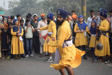 Delhi, Hindistan, 17 Kasım 2024 - Doğu Delhi bölgesinde Guru Nanak Dev, Nagar Kirtan 'ın doğum günü dolayısıyla geleneksel Nagar Kirtan, geleneksel Nagar geçit töreninde Sihler gatka ve dövüş sanatlarını sergiliyor