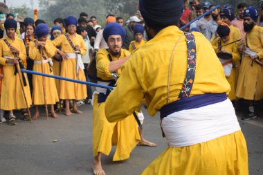 Delhi, Hindistan, 17 Kasım 2024 - Doğu Delhi bölgesinde Guru Nanak Dev, Nagar Kirtan 'ın doğum günü dolayısıyla geleneksel Nagar Kirtan, geleneksel Nagar geçit töreninde Sihler gatka ve dövüş sanatlarını sergiliyor