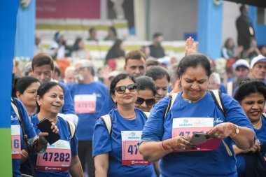 Yeni Delhi, Hindistan - 20 Ekim 2024 - Vedanta Delhi Yarı Maraton yarışına katılan yaşlılar maraton katılımcılarının bitiş çizgisini geçmek üzere oldukları Delhi Yarı Maratonu 2024