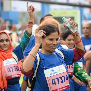 Yeni Delhi, Hindistan - 20 Ekim 2024 - Vedanta Delhi Yarı Maraton yarışına katılan yaşlılar maraton katılımcılarının bitiş çizgisini geçmek üzere oldukları Delhi Yarı Maratonu 2024