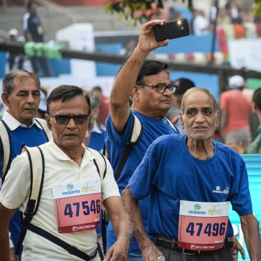 Yeni Delhi, Hindistan - 20 Ekim 2024 - Vedanta Delhi Yarı Maraton yarışına katılan yaşlılar maraton katılımcılarının bitiş çizgisini geçmek üzere oldukları Delhi Yarı Maratonu 2024