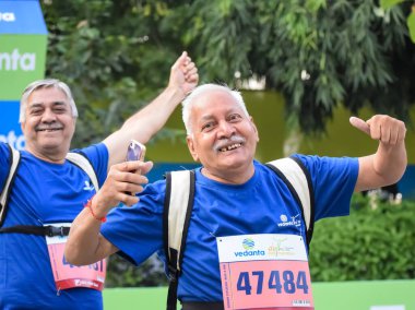 Yeni Delhi, Hindistan - 20 Ekim 2024 - Vedanta Delhi Yarı Maraton yarışına katılan yaşlılar maraton katılımcılarının bitiş çizgisini geçmek üzere oldukları Delhi Yarı Maratonu 2024