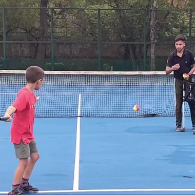 Delhi, Hindistan, 17 Şubat 2025 - Maha Open için kil tenis kortunda antrenörlük yapan genç tenisçiler, yaklaşan turnuva için küçük tenis oyuncuları antrenman yapıyor