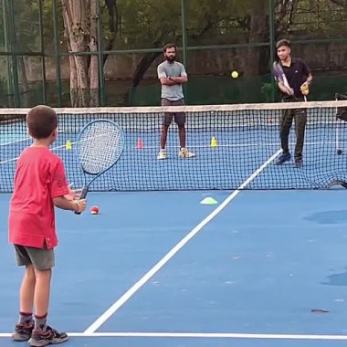 Delhi, Hindistan, 17 Şubat 2025 - Maha Open için kil tenis kortunda antrenörlük yapan genç tenisçiler, yaklaşan turnuva için küçük tenis oyuncuları antrenman yapıyor