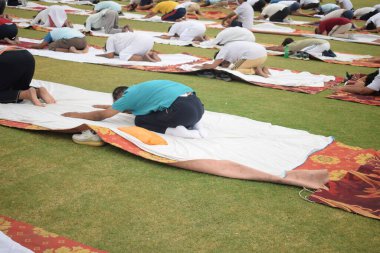 Yeni Delhi, Hindistan, 21 Haziran 2025 - Uluslararası Yoga Günü 'nde Delhi' deki Yamuna Spor Kompleksi 'nde grup Yoga egzersiz oturumu, kriket stadyumunda yoga sınıfına katılan büyük bir grup yetişkin
