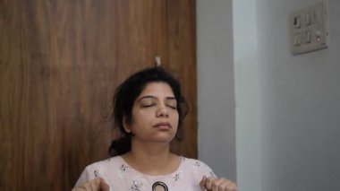 Evde yoga yapan genç Hintli bir kadın çevrimiçi yoga seansında güzel bir kız temel yoga pozisyonunda Asyalı bir kadın kapalı alanda yoga yapıyor. 