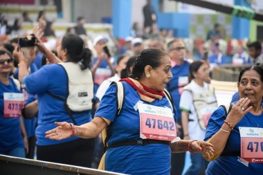 Yeni Delhi, Hindistan - 20 Ekim 2024 - Vedanta Delhi Yarı Maraton yarışına katılan yaşlılar maraton katılımcılarının bitiş çizgisini geçmek üzere oldukları Delhi Yarı Maratonu 2024