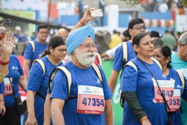 Yeni Delhi, Hindistan - 20 Ekim 2024 - Vedanta Delhi Yarı Maraton yarışına katılan yaşlılar maraton katılımcılarının bitiş çizgisini geçmek üzere oldukları Delhi Yarı Maratonu 2024