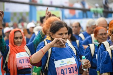 Yeni Delhi, Hindistan - 20 Ekim 2024 - Vedanta Delhi Yarı Maraton yarışına katılan yaşlılar maraton katılımcılarının bitiş çizgisini geçmek üzere oldukları Delhi Yarı Maratonu 2024