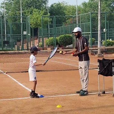 Delhi, Hindistan, 17 Şubat 2025 - Maha Open için kil tenis kortunda antrenörlük yapan genç tenisçiler, yaklaşan turnuva için küçük tenis oyuncuları antrenman yapıyor