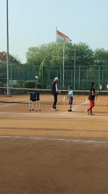 Delhi, Hindistan, 17 Şubat 2025 - Maha Open için kil tenis kortunda antrenörlük yapan genç tenisçiler, yaklaşan turnuva için küçük tenis oyuncuları antrenman yapıyor