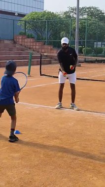 Delhi, Hindistan, 17 Şubat 2025 - Maha Open için kil tenis kortunda antrenörlük yapan genç tenisçiler, yaklaşan turnuva için küçük tenis oyuncuları antrenman yapıyor