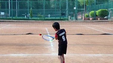 Delhi, Hindistan, 17 Şubat 2025 - Maha Open için kil tenis kortunda antrenörlük yapan genç tenisçiler, yaklaşan turnuva için küçük tenis oyuncuları antrenman yapıyor