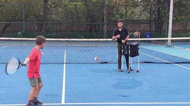 Delhi, Hindistan, 17 Şubat 2025 - Maha Open için kil tenis kortunda antrenörlük yapan genç tenisçiler, yaklaşan turnuva için küçük tenis oyuncuları antrenman yapıyor