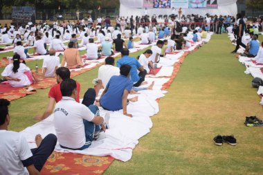 Yeni Delhi, Hindistan, 21 Haziran 2025 - Uluslararası Yoga Günü 'nde Delhi' deki Yamuna Spor Kompleksi 'nde grup Yoga egzersiz oturumu, kriket stadyumunda yoga sınıfına katılan büyük bir grup yetişkin