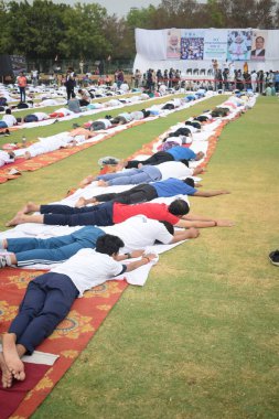 Yeni Delhi, Hindistan, 21 Haziran 2025 - Uluslararası Yoga Günü 'nde Delhi' deki Yamuna Spor Kompleksi 'nde grup Yoga egzersiz oturumu, kriket stadyumunda yoga sınıfına katılan büyük bir grup yetişkin