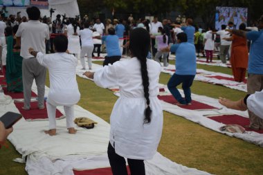 Yeni Delhi, Hindistan, 21 Haziran 2025 - Uluslararası Yoga Günü 'nde Delhi' deki Yamuna Spor Kompleksi 'nde grup Yoga egzersiz oturumu, kriket stadyumunda yoga sınıfına katılan büyük bir grup yetişkin