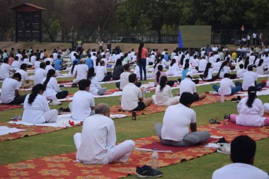 Yeni Delhi, Hindistan, 21 Haziran 2025 - Uluslararası Yoga Günü 'nde Delhi' deki Yamuna Spor Kompleksi 'nde grup Yoga egzersiz oturumu, kriket stadyumunda yoga sınıfına katılan büyük bir grup yetişkin