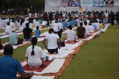 Yeni Delhi, Hindistan, 21 Haziran 2025 - Uluslararası Yoga Günü 'nde Delhi' deki Yamuna Spor Kompleksi 'nde grup Yoga egzersiz oturumu, kriket stadyumunda yoga sınıfına katılan büyük bir grup yetişkin