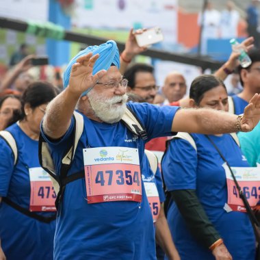 Yeni Delhi, Hindistan - 20 Ekim 2024 - Vedanta Delhi Yarı Maraton yarışına katılan yaşlılar maraton katılımcılarının bitiş çizgisini geçmek üzere oldukları Delhi Yarı Maratonu 2024