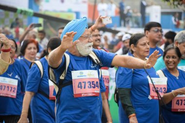 Yeni Delhi, Hindistan - 20 Ekim 2024 - Vedanta Delhi Yarı Maraton yarışına katılan yaşlılar maraton katılımcılarının bitiş çizgisini geçmek üzere oldukları Delhi Yarı Maratonu 2024