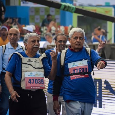 Yeni Delhi, Hindistan - 20 Ekim 2024 - Vedanta Delhi Yarı Maraton yarışına katılan yaşlılar maraton katılımcılarının bitiş çizgisini geçmek üzere oldukları Delhi Yarı Maratonu 2024