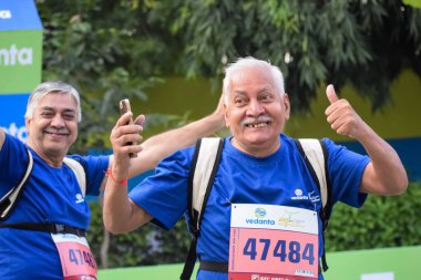 Yeni Delhi, Hindistan - 20 Ekim 2024 - Vedanta Delhi Yarı Maraton yarışına katılan yaşlılar maraton katılımcılarının bitiş çizgisini geçmek üzere oldukları Delhi Yarı Maratonu 2024