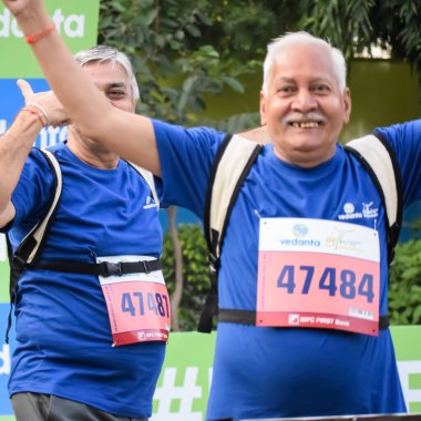 Yeni Delhi, Hindistan - 20 Ekim 2024 - Vedanta Delhi Yarı Maraton yarışına katılan yaşlılar maraton katılımcılarının bitiş çizgisini geçmek üzere oldukları Delhi Yarı Maratonu 2024
