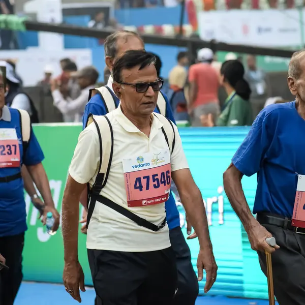 Yeni Delhi, Hindistan - 20 Ekim 2024 - Vedanta Delhi Yarı Maraton yarışına katılan yaşlılar maraton katılımcılarının bitiş çizgisini geçmek üzere oldukları Delhi Yarı Maratonu 2024