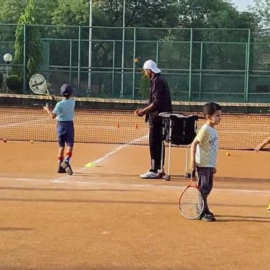 Delhi, Hindistan, 17 Şubat 2025 - Maha Open için kil tenis kortunda antrenörlük yapan genç tenisçiler, yaklaşan turnuva için küçük tenis oyuncuları antrenman yapıyor