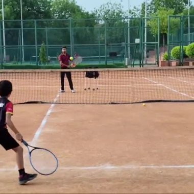 Delhi, Hindistan, 17 Şubat 2025 - Maha Open için kil tenis kortunda antrenörlük yapan genç tenisçiler, yaklaşan turnuva için küçük tenis oyuncuları antrenman yapıyor