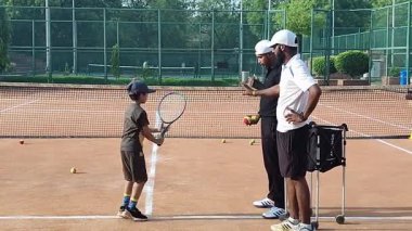 Delhi, Hindistan, 17 Şubat 2025 - Maha Open için kil tenis kortunda antrenörlük yapan genç tenisçiler, yaklaşan turnuva için küçük tenis oyuncuları antrenman yapıyor